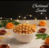 Bowl of Chettinad Seedai with decorative elements on a dark background